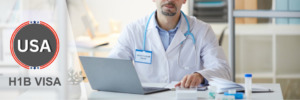 Doctor at a desk using a laptop, representing healthcare professionals on H1B visas.