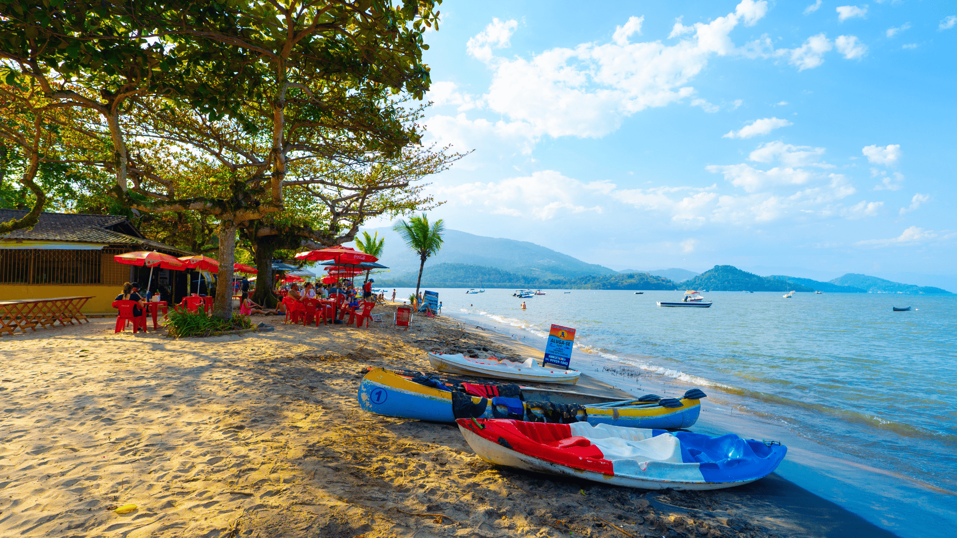 Praia do Pontal beach in Paraty, Brazil, with calm bay water and forested hills