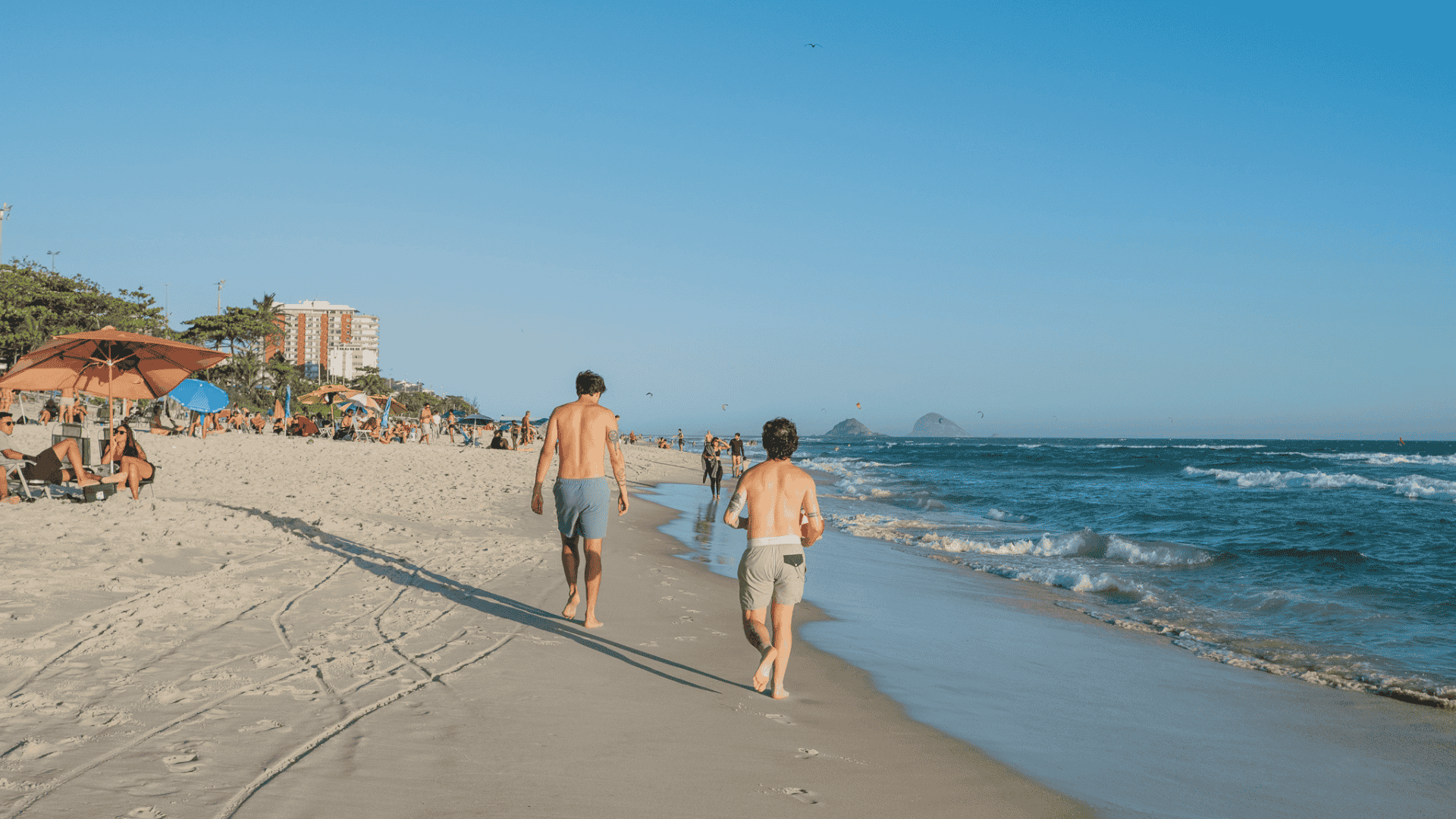 People enjoying a sunny day at Barra da Tijuca beach, in Rio de Janeiro